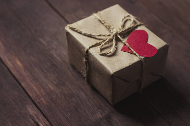 Подарочная коробка с красным сердцем на деревянном фоне
 - Фото, изображение