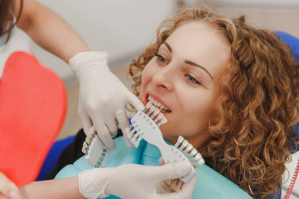 Zubař srovnání zubů odstínu s vzorky pro bělení léčby pacienta - Fotografie, Obrázek