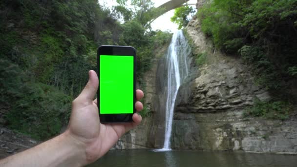 Eine Hand hält ein Telefon mit grünem Bildschirm - Filmmaterial, Video