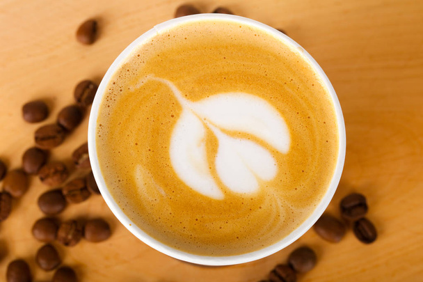 Beyaz fincan kahve kapuçino kızarmış kahve çekirdekleri ile - Fotoğraf, Görsel