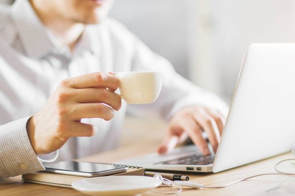 Man drinking coffee using laptop  - Photo, image