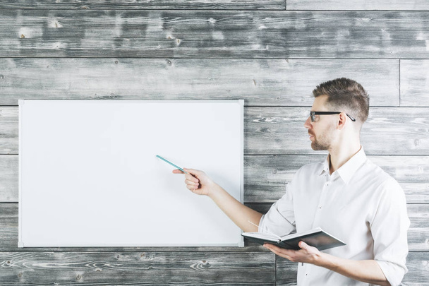 Handsome man pointing at whiteboard  - Photo, Image