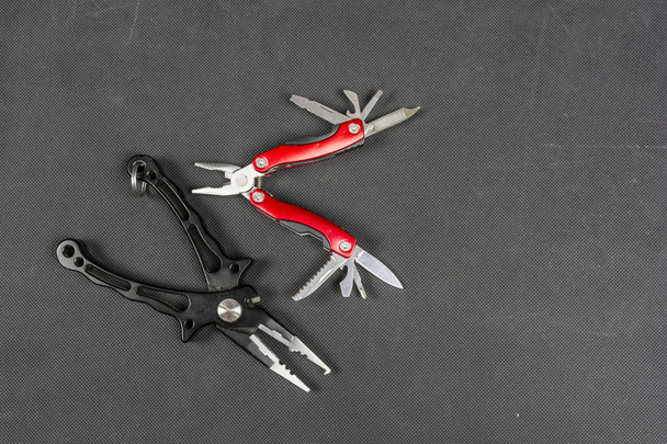 Black pliers and red folding multifunctional tool for anglers. - Photo, Image