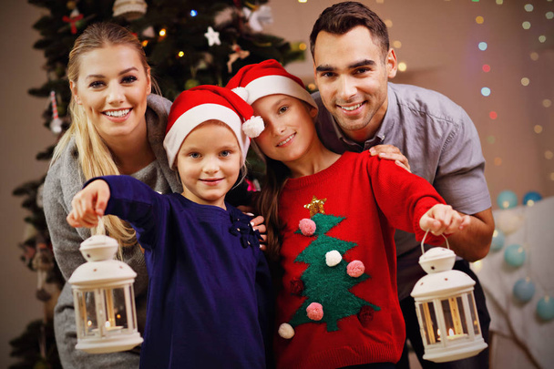 Gelukkige familie poseren met Kerstmis lantaarns - Foto, afbeelding