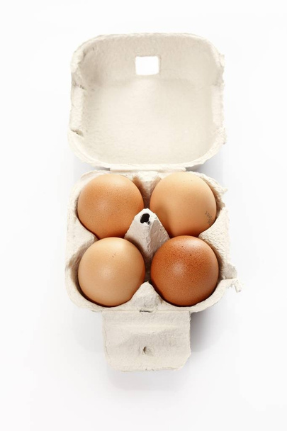 Four eggs in a cardboard box - Fotoğraf, Görsel