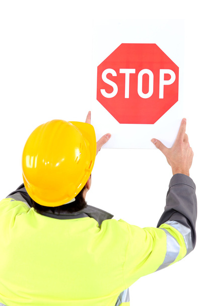Builder affixing stop sign - Photo, Image