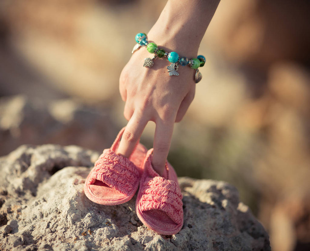 Woman mother holding in hands her future baby girl child pinky shoes sandals.Emotional scene of mother care love maternity - Photo, Image