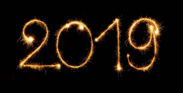 2019 with sparklers on black background - Foto, Bild