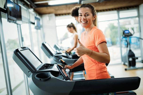 Young attractive woman doing cardio training for weight loss in gym - Photo, image