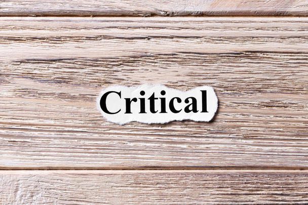 CRITICAL of the word on paper. concept. Words of CRITICAL on a wooden background - Photo, Image