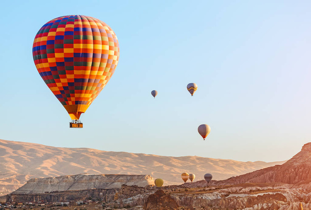 Kleurrijke luchtballon vliegt over rots landschap aan Cappadocië-Turkije - Foto, afbeelding