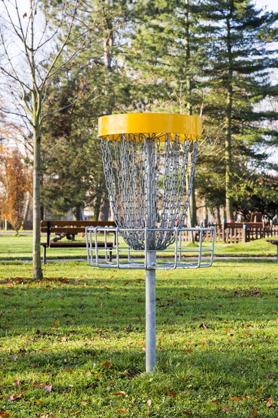 Panier à jouer avec des chaînes pour lancer des disques volants dans le parc avec des arbres et de l'herbe
 - Photo, image