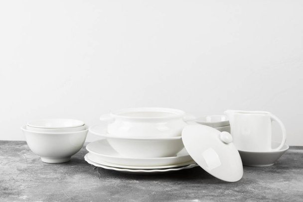 Clean white tableware on a gray background - Photo, Image