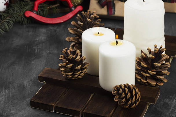 Burning candles and Christmas attributes on a dark background. C - Photo, image