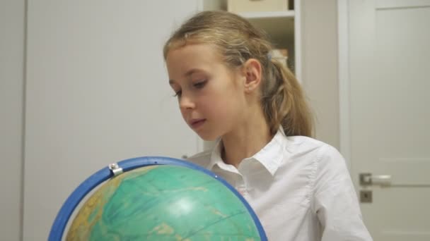 Little girl is studying the globe at home. - Metraje, vídeo