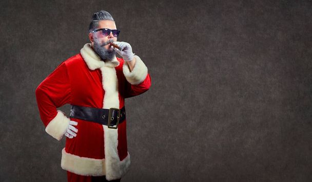 Santa Claus with a fashion hairdress smokes a cigar. - Photo, Image