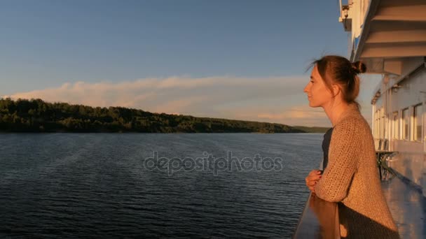 Mulher admirando o pôr do sol do convés do navio de cruzeiro
 - Filmagem, Vídeo