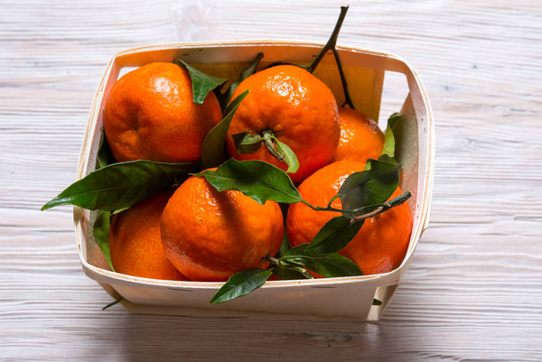 Fresh Mandarin with green leaves on wooden table - Photo, Image