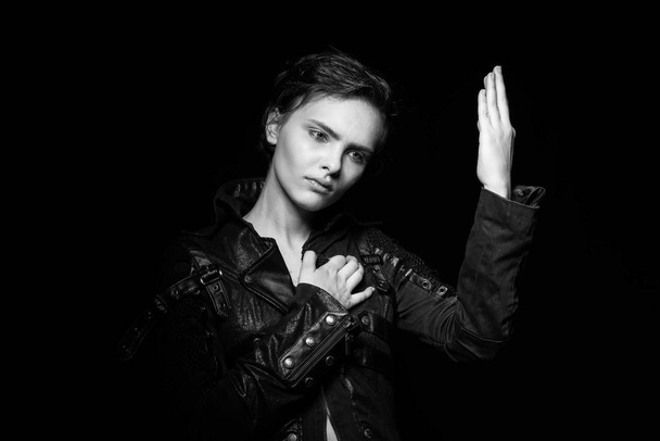 Emotive black and white portrait of cute young woman wearing leather jacket. - Фото, изображение