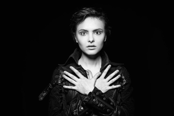 Emotive black and white portrait of cute young woman wearing leather jacket. - Photo, image