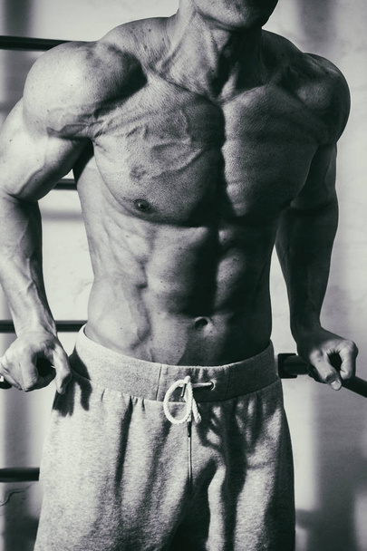 Brutális erős sportos férfi szivattyúzás fel izmok edzés bodybuildi - Fotó, kép