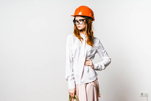 confiant fille sérieuse dans un casque de protection orange et des lunettes pose
 - Photo, image