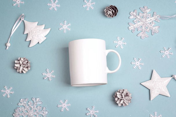 White coffee mug  with Christmas decorations on blue background. - Фото, изображение