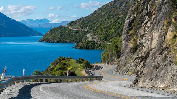 Звивиста дорога вздовж гірські скелі і озеро - Фото, зображення