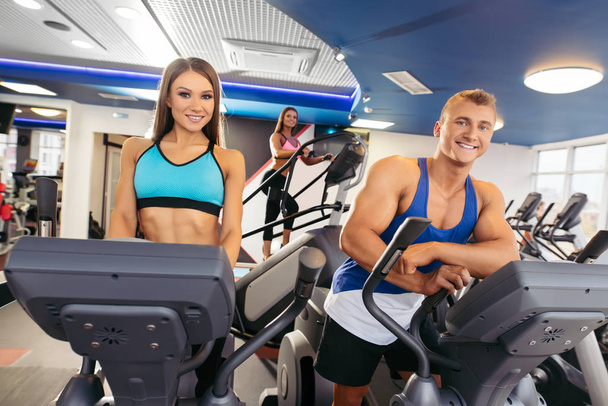 Young couple running on bikes in fitness gym - Foto, Imagem