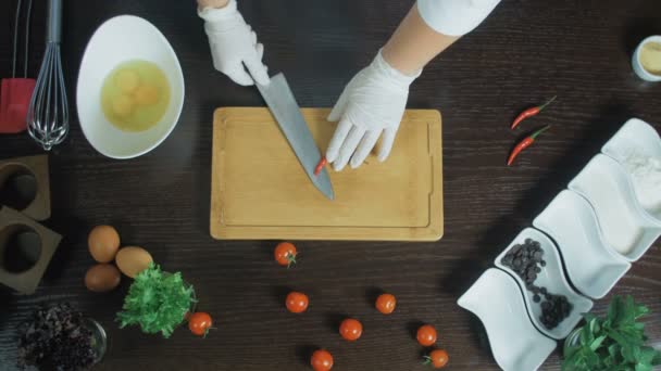 Vista superior. Chef cortando uma cenoura com pimenta vermelha na tábua de corte. Remover sementes
 - Filmagem, Vídeo