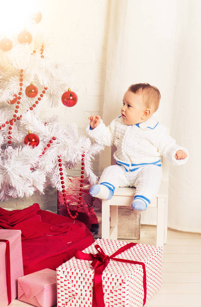 Bambino con albero di Natale decorato al chiuso
 - Foto, immagini