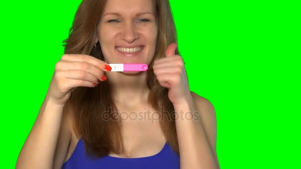 Emotional girl showing pregnancy test with two stripes and look at camera - Materiaali, video