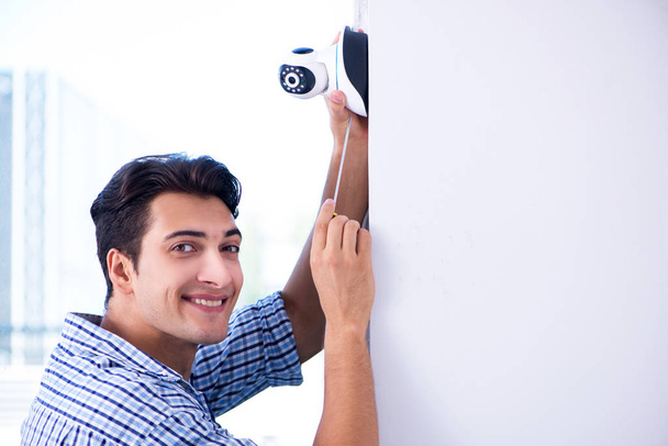 Homme installant des caméras de surveillance CCTV à la maison - Photo, image