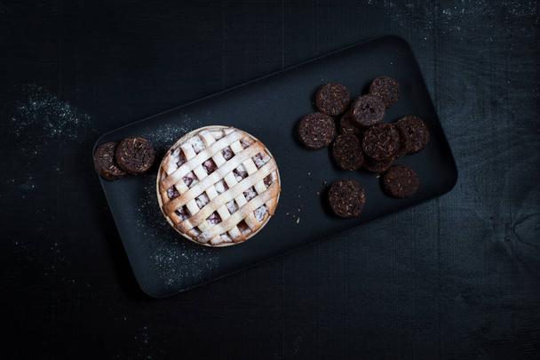 American Pie with cookies . On a black plate - Foto, afbeelding