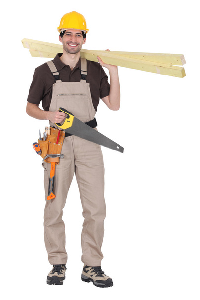 Craftsman holding wooden boards and a saw - Photo, image