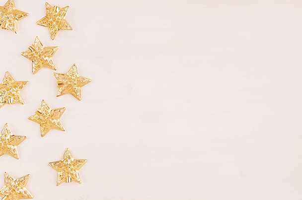 Festive decorations, gold stars on white wooden background. - Foto, afbeelding