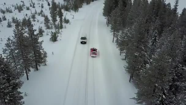 Veduta aerea della macchina rossa sulla strada nel bellissimo paesaggio invernale della Lapponia durante una nevicata. Tracciamento lineare dell'auto. Video aereo
.  - Filmati, video