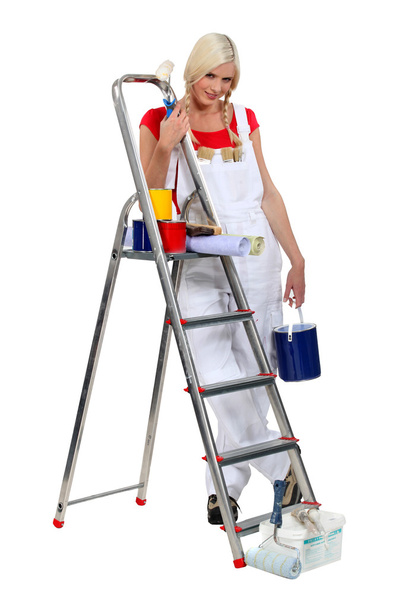 Blond woman stood by ladder holding paint pot - Zdjęcie, obraz