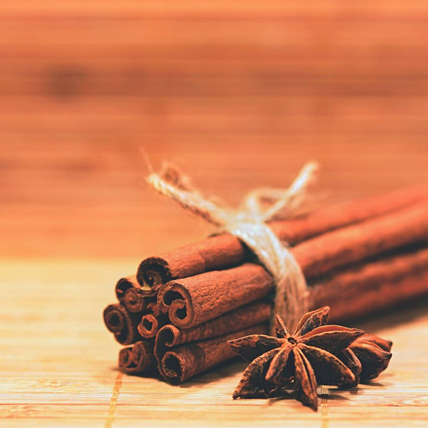Cinnamon and star anise on a wooden background. Beautiful and fragrant spices for Christmas time and winter cooking season. - Photo, Image