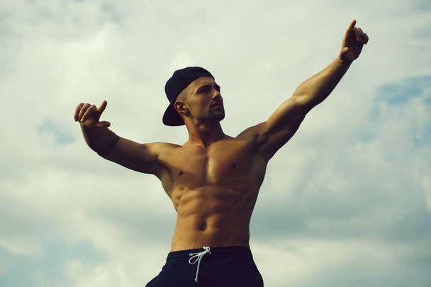 Sexy muscular man on sky background - Foto, imagen