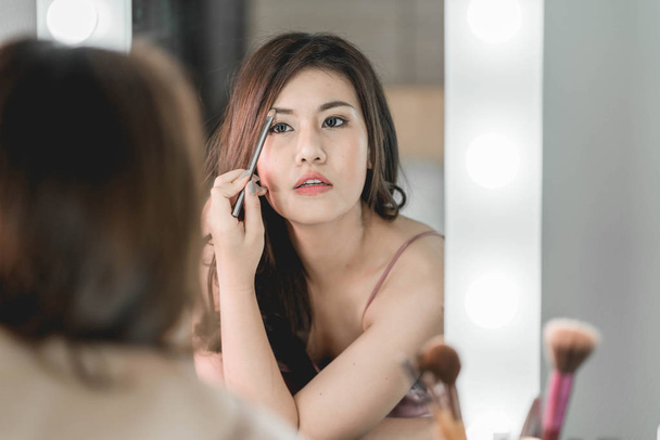 Young Beautiful Asian Woman making make-up near mirror - Foto, Imagem