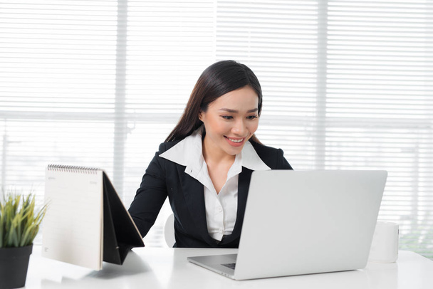 Vertrouwen Aziatische zakenvrouw zitten aan de balie in kantoor - Foto, afbeelding