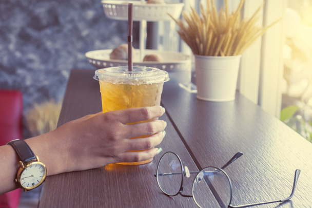 mão segurando copo de plástico de chá de gelo
 - Foto, Imagem