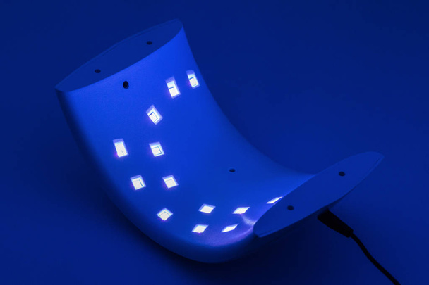 UV lambası çivi için karanlık bir arka plan üzerinde ışıklar. - Fotoğraf, Görsel