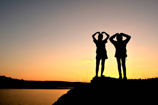 Silhouette donne e ragazza zaino in spalla sulla cima della montagna
  - Foto, immagini