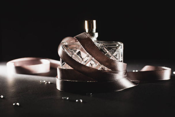 Жіночі парфуми на темному тлі
 - Фото, зображення