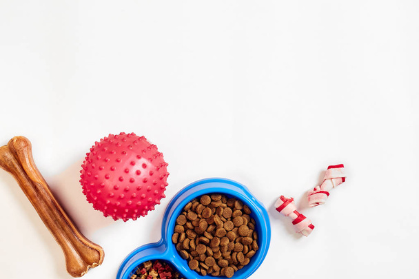 suchém krmivu v misce a hračky pro psy na bílém pozadí pohled shora - Fotografie, Obrázek