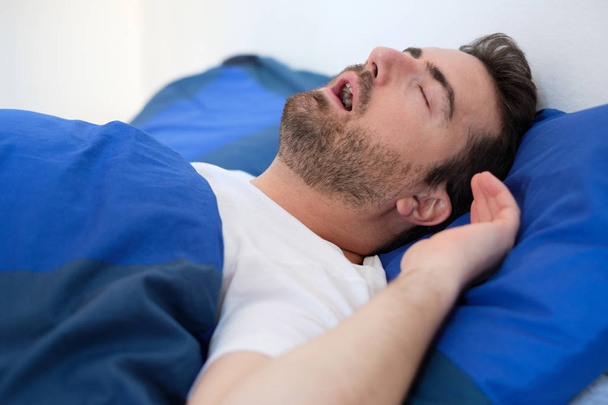  Uomo a letto che soffre di sindrome da apnea del sonno
 - Foto, immagini