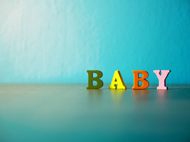 Μωρό. Αγγλικό αλφάβητο αποτελείται από ξύλινο γράμμα χρώμα. Αλφάβητο μωρό σε ξύλινο τραπέζι και το φόντο είναι μπλε σκόνη. - Φωτογραφία, εικόνα