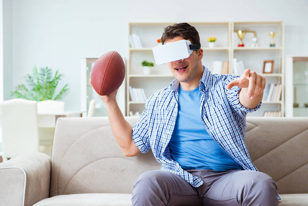Man wearing virtual reality VR glasses watching american footbal - 写真・画像